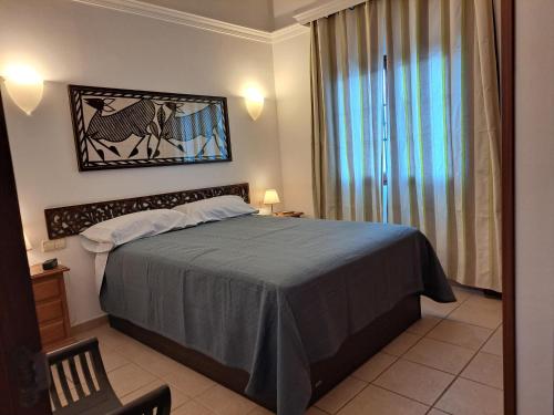 Un dormitorio con una cama grande y una ventana. en Villa de la Paz, en Playa Blanca