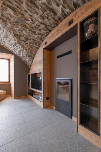 a living room with a fireplace and a tv at Grande Cote Room and Breakfast in Cesana Torinese