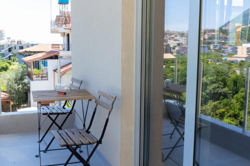 a balcony with a table and chairs on a balcony at De Sol in Himare
