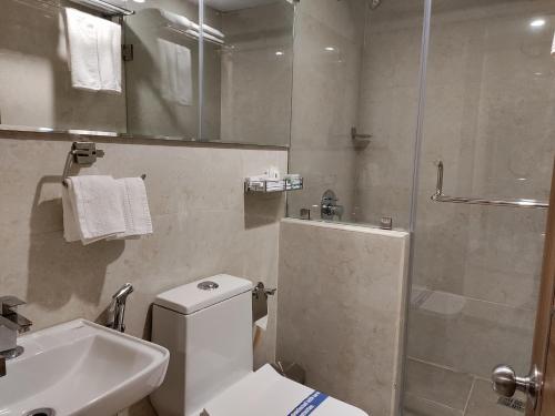 a bathroom with a toilet and a shower and a sink at Zing Rooms by GuestHouse Suites in Bengaluru