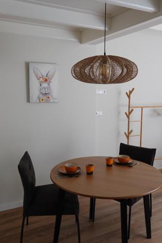 a dining room table with two chairs and a lamp at Terras kamer in Spang