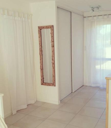 une pièce blanche avec un miroir sur un mur dans l'établissement Oyat gîte écologique à Porspoder, à Porspoder