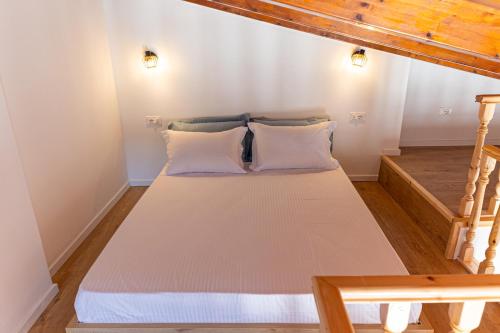 a bed with two pillows in a room at De Sol in Himare