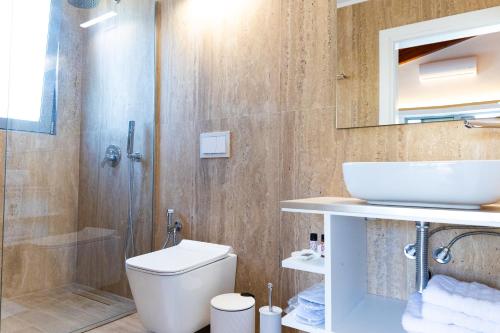 a bathroom with a toilet and a sink and a shower at De Sol in Himare