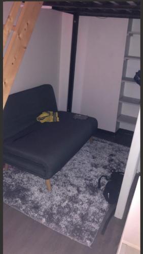 une chaise noire dans une pièce avec une échelle dans l'établissement appartement proche centre ville, à Nice