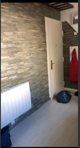 Cette chambre est dotée d'un mur en briques et d'une porte blanche. dans l'établissement appartement proche centre ville, à Nice