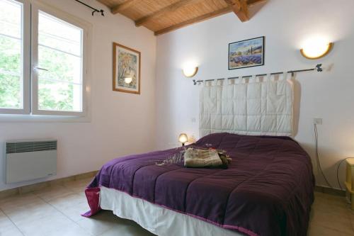 - une chambre avec un lit doté d'un couvre-lit violet et 2 fenêtres dans l'établissement Appartement indépendant dans mas, à Arles