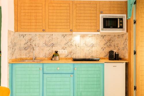 a kitchen with blue cabinets and a microwave at Casa Esmeralda - Luxury Boutique Apartments Old Town in Estepona