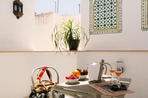 a table with a bowl of fruit and wine glasses at Casa Esmeralda - Luxury Boutique Apartments Old Town in Estepona