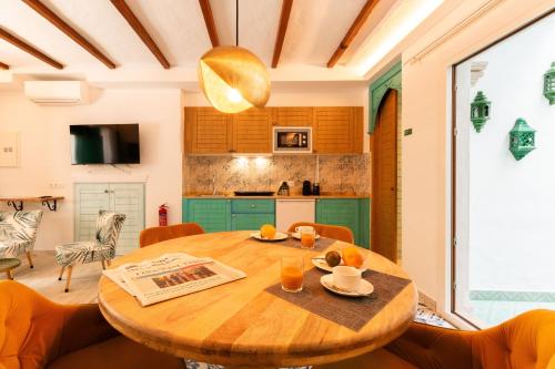 a kitchen and dining room with a wooden table at Casa Esmeralda - Luxury Boutique Apartments Old Town in Estepona