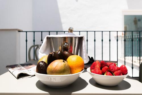 two bowls of fruit on a table with a juicer at Casa Esmeralda - Luxury Boutique Apartments Old Town in Estepona