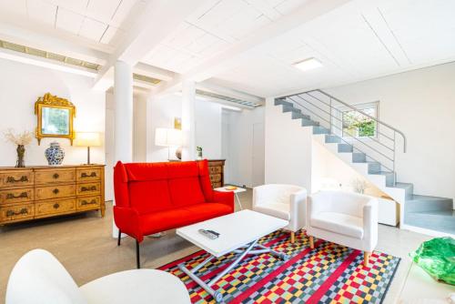 a living room with a red chair and a rug at GuestReady - Charming haven with a private garden in Nogent-sur-Marne