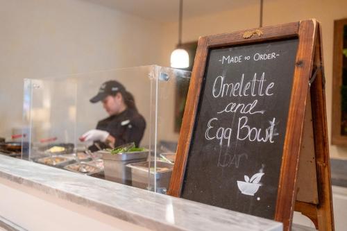a woman preparing food in a restaurant kitchen with a sign at Omni Orlando Resort at Championsgate in Kissimmee