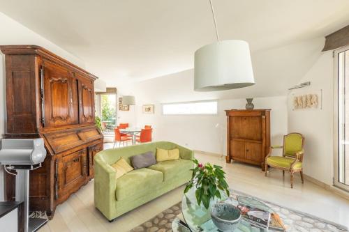 un salon avec un canapé vert et une table dans l'établissement GuestReady- 2 Terrace Duplex with Exceptional View, à Paris