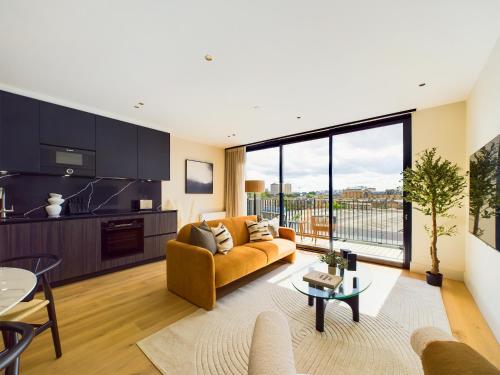 a living room with a couch and a table at Be London - The St Pancras Residences in London