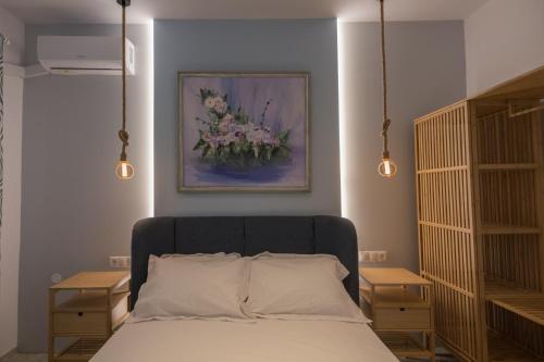 a bedroom with a bed with a painting on the wall at Para Thin Alos Skiathos in Skiathos
