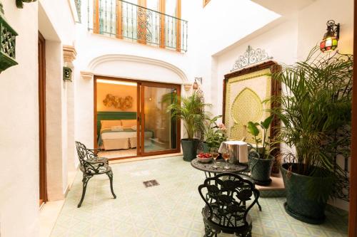 a courtyard with a table and chairs and potted plants at Casa Esmeralda - Luxury Boutique Apartments Old Town in Estepona