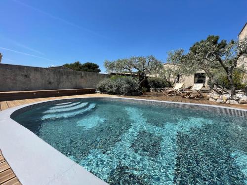 une piscine avec de l'eau bleue dans une cour dans l'établissement Maison chaleureuse avec piscine, à Mérindol