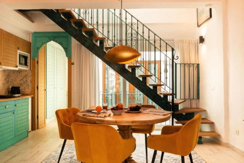 a kitchen and dining room with a table and a staircase at Casa Esmeralda - Luxury Boutique Apartments Old Town in Estepona