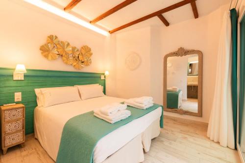 a bedroom with a bed and a mirror at Casa Esmeralda - Luxury Boutique Apartments Old Town in Estepona