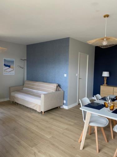 une chambre avec un lit, une table et des chaises dans l'établissement Appartement 65m2 avec balcon vues partielles mer à 150m de la plage et centre, wifi et parking privé, à Blonville-sur-Mer