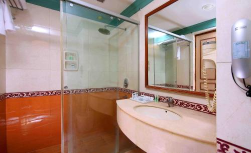 a bathroom with a sink and a mirror at Royal Court in Madurai