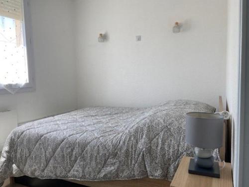 une chambre avec un lit et une lampe sur une table dans l'établissement Appartement T2 pour 4 Personnes Résidence avec piscine 4EURO213 Nice apartment with swimming pool, à Canet