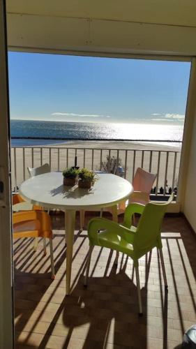une table et des chaises sur un balcon avec vue sur l'océan dans l'établissement Grand appartement vue sur mer, au Grau-dʼAgde