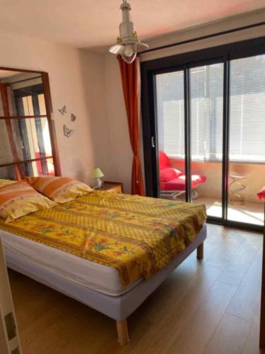 une chambre avec un lit et une porte coulissante en verre dans l'établissement LES GABIANS - Appartement T2 - TIKI PLAGE - Saint Raphaël, à Saint-Raphaël