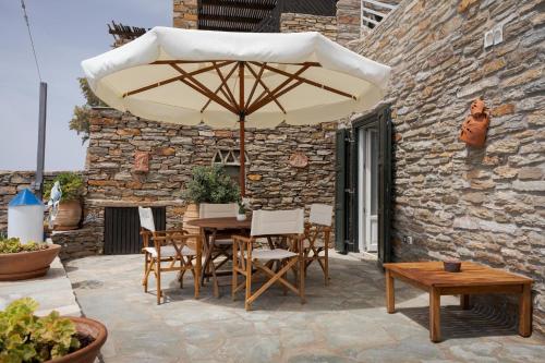a table and chairs with an umbrella on a patio at Kea Blue Heaven in Koundouros