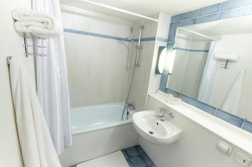 ein Badezimmer mit einem Waschbecken, einer Badewanne und einem WC in der Unterkunft Campanile Nevers Nord - Varennes-Vauzelles in Varennes-Vauzelles