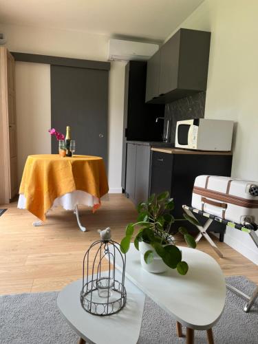 un salon avec une table et une cuisine dans l'établissement Studio près de Versailles au calme, à Vaucresson