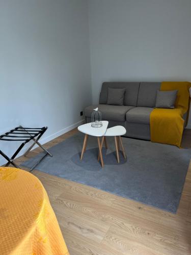 un salon avec un canapé et une table dans l'établissement Studio près de Versailles au calme, à Vaucresson