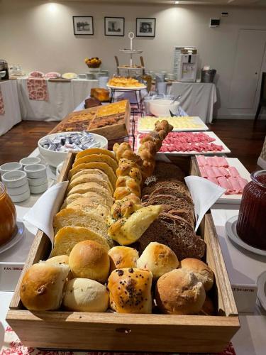 una mesa llena de diferentes tipos de pan y repostería en Kenton Palace Buenos Aires, en Buenos Aires