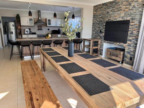 a dining room with a wooden table and a kitchen at At 47 Turmalin Holiday House in Swakopmund