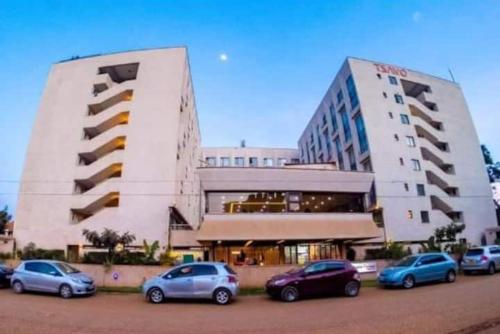 a large building with cars parked in front of it at Tsavo Coral Bells in Kiambu