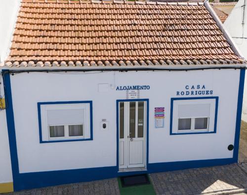 a small blue and white building with a door at Casa Rodrigues in Santiago do Cacém