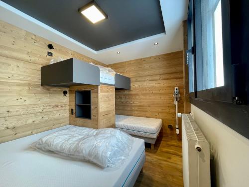 une petite chambre avec un lit et une télévision dans l'établissement Homency - Résidence Kandahar 20, à L'Alpe-d'Huez