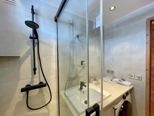 une salle de bain avec douche et lavabo dans l'établissement Homency - Résidence Kandahar 20, à L'Alpe-d'Huez
