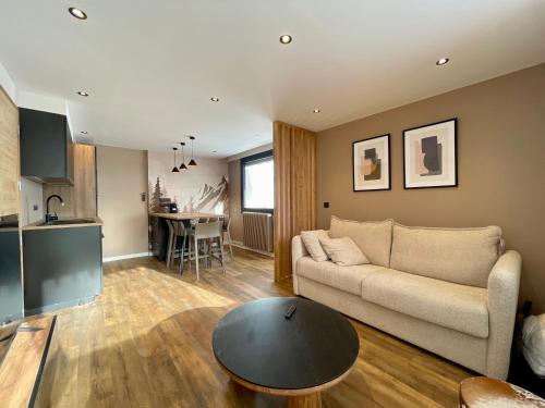 un salon avec un canapé et une table dans l'établissement Homency - Résidence Kandahar 20, à L'Alpe-d'Huez