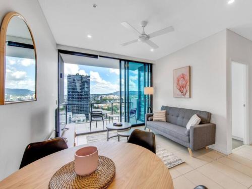 a living room with a table and a couch at Modern Mountain View Apartment - South Brisbane in Brisbane