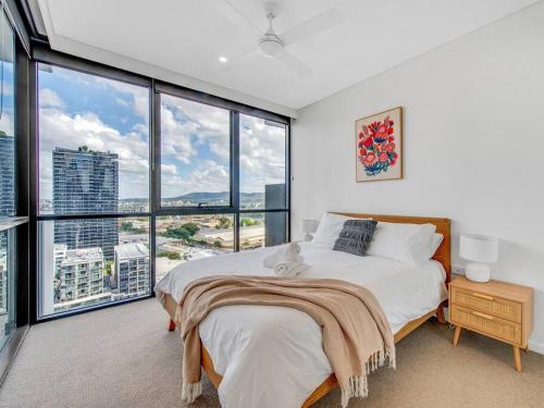 a bedroom with a large bed and large windows at Modern Mountain View Apartment - South Brisbane in Brisbane