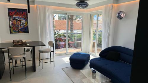 un salon avec un canapé bleu et une table dans l'établissement Cavalaire plein centre, Appartement design 70m2 à 2mn de la plage - Garage privé -Terrasse, à Cavalaire-sur-Mer