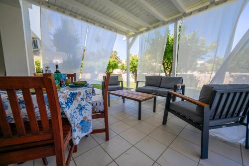 a screened in porch with chairs and a table at Villa Venera Fontane Bianche Charme Apartments in Fontane Bianche