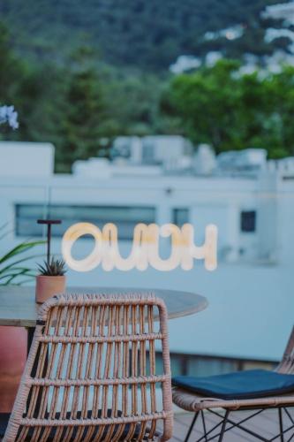 a wicker chair sitting in front of a table with the word course at Nativo Hotel Ibiza in Santa Eularia des Riu