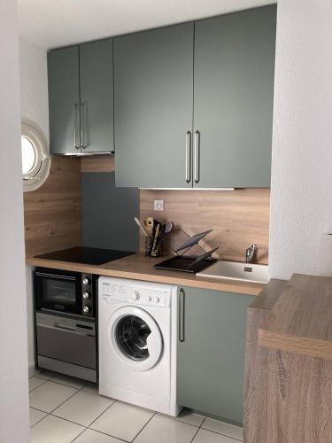 une cuisine avec une machine à laver et un évier dans l'établissement Appartement T2 lumineux et moderne avec parking - 4VOIL245 -, à Canet