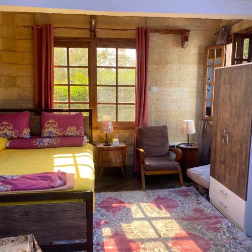 a bedroom with a bed and a chair and a window at Sunny airport studio New Cairo in Cairo