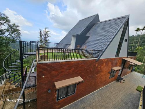 a house with a roof with a staircase on it at Villa Aven - Premium Suits in Kakkadampoyil