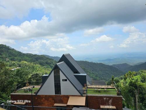 a building with a roof on top of a mountain at Villa Aven - Premium Suits in Kakkadampoyil