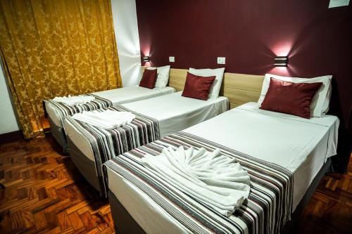 a hotel room with three beds in a room at Hotel Euro Suite Poços de Caldas By Nacional Inn in Poços de Caldas